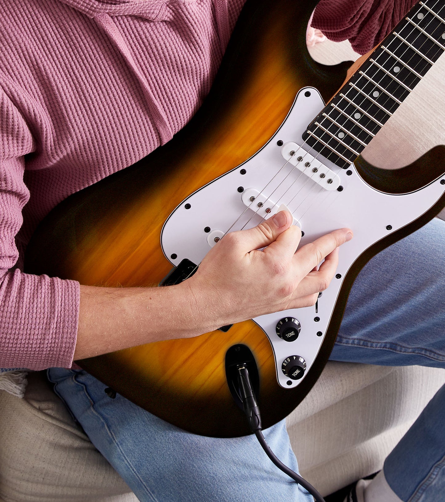 person playing Sunburst beginner electric guitar