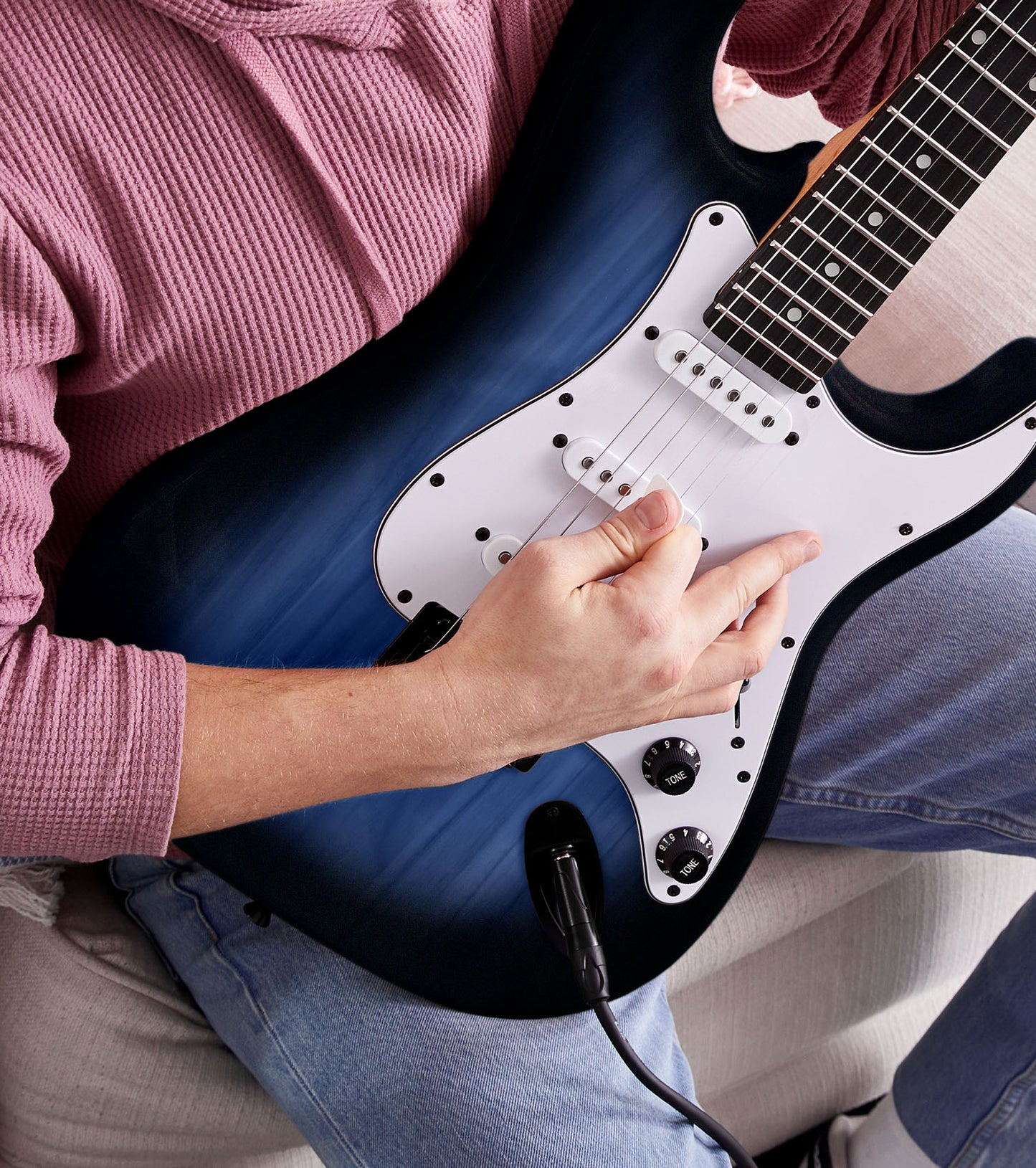 person playing Blue beginner electric guitar