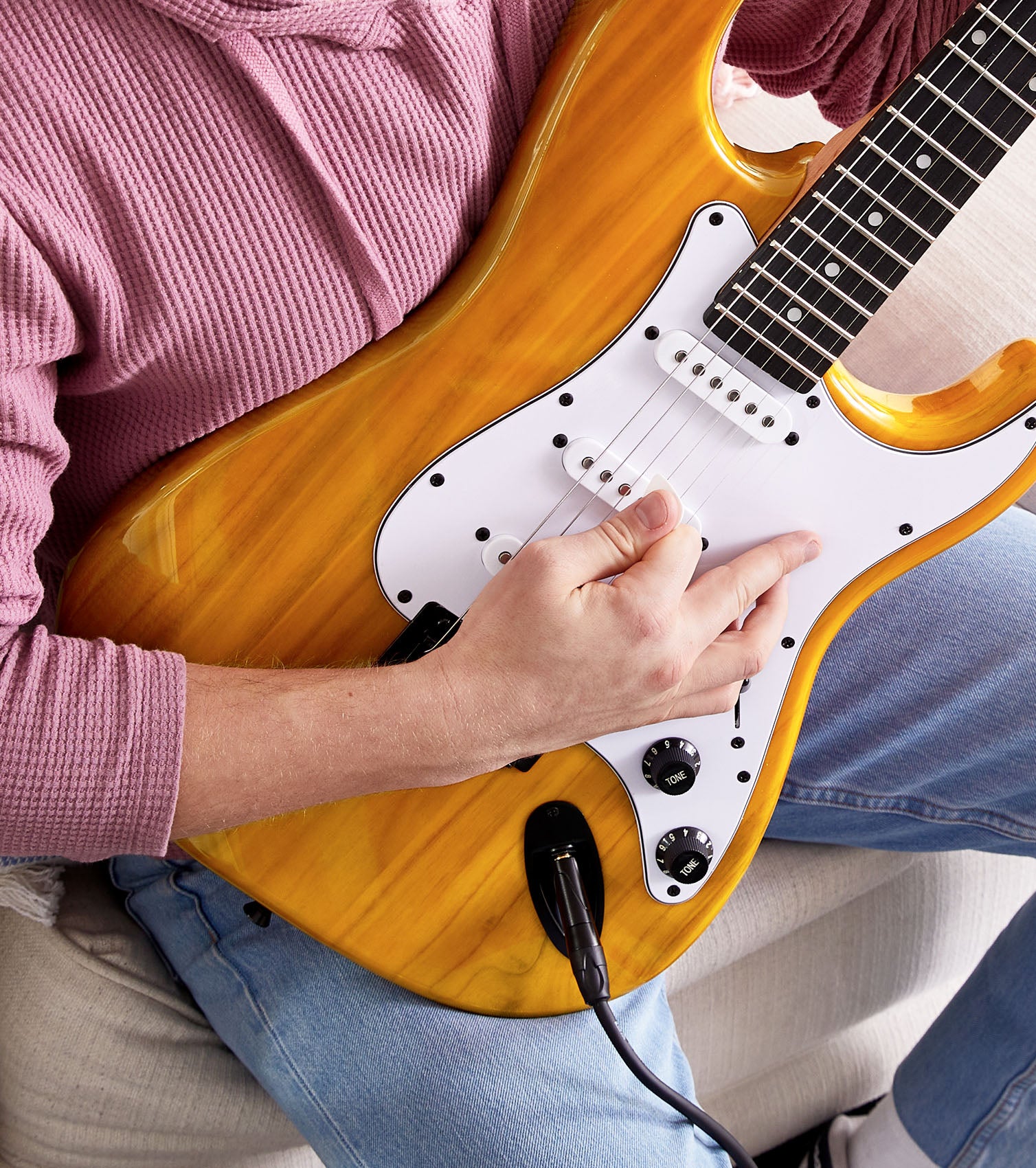 person playing Mahogany beginner electric guitar