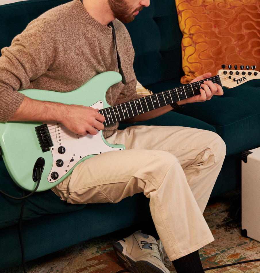 a person playing a light green electric guitar