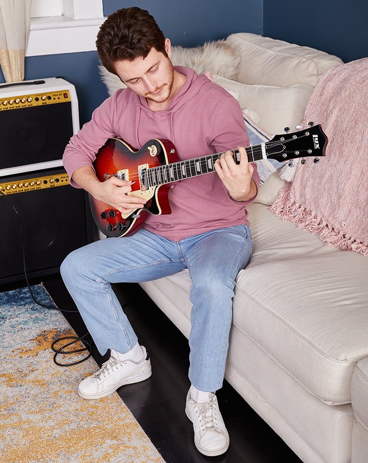 Man playing guitar on couch