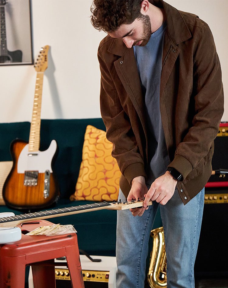 man repairing guitar