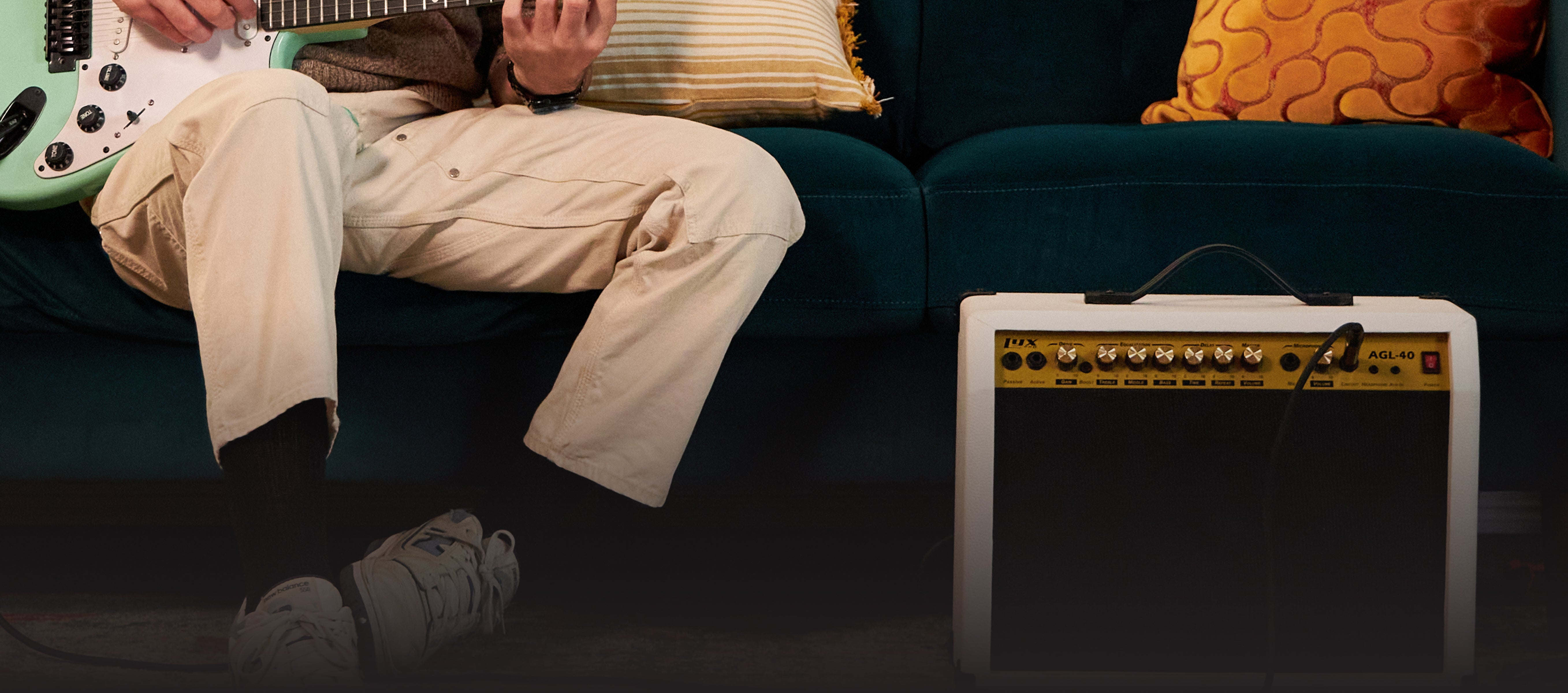 a person playing the beginner electric guitar plugged into their portable guitar amp 