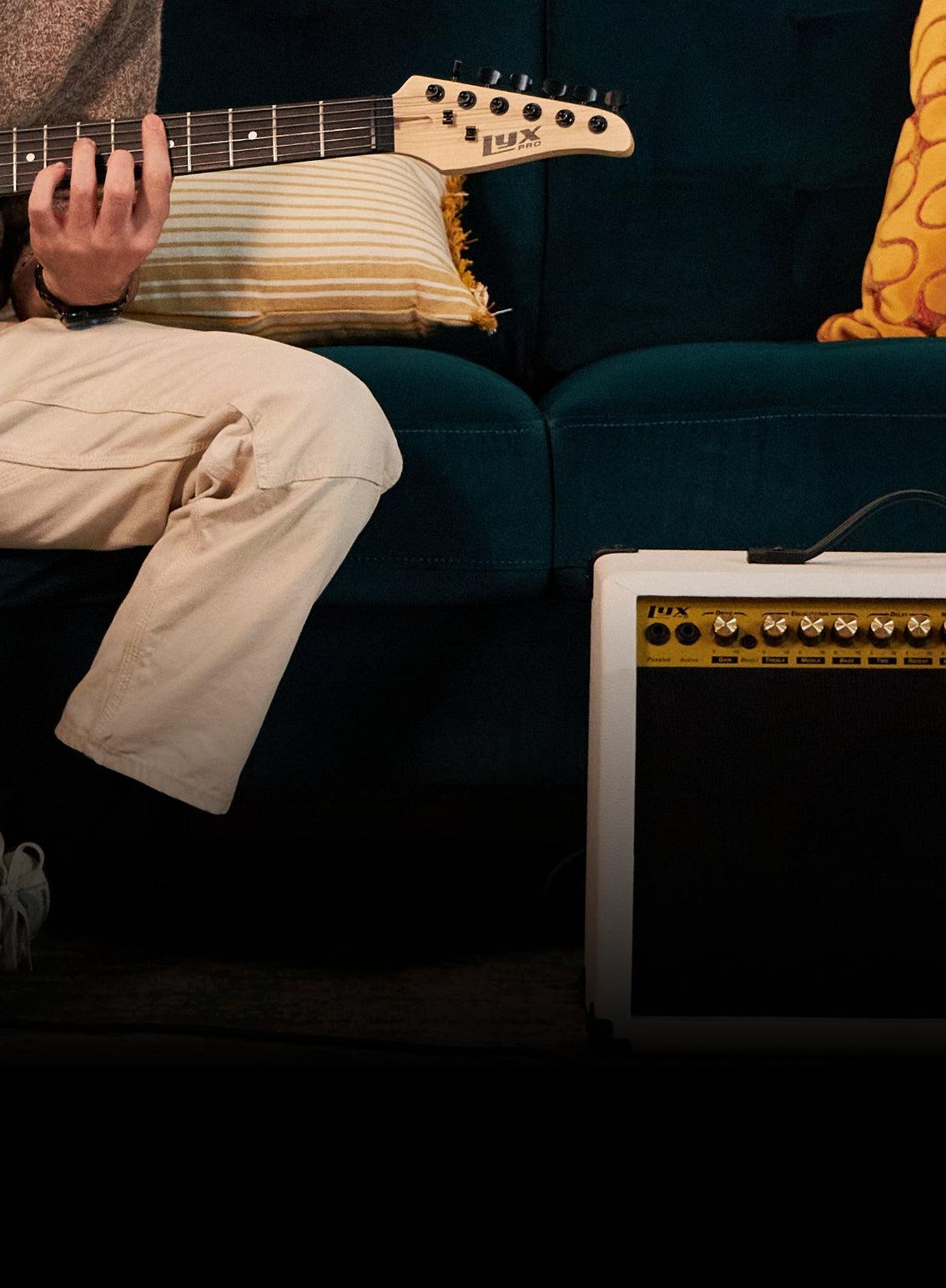 a person playing the beginner electric guitar plugged into their portable guitar amp 