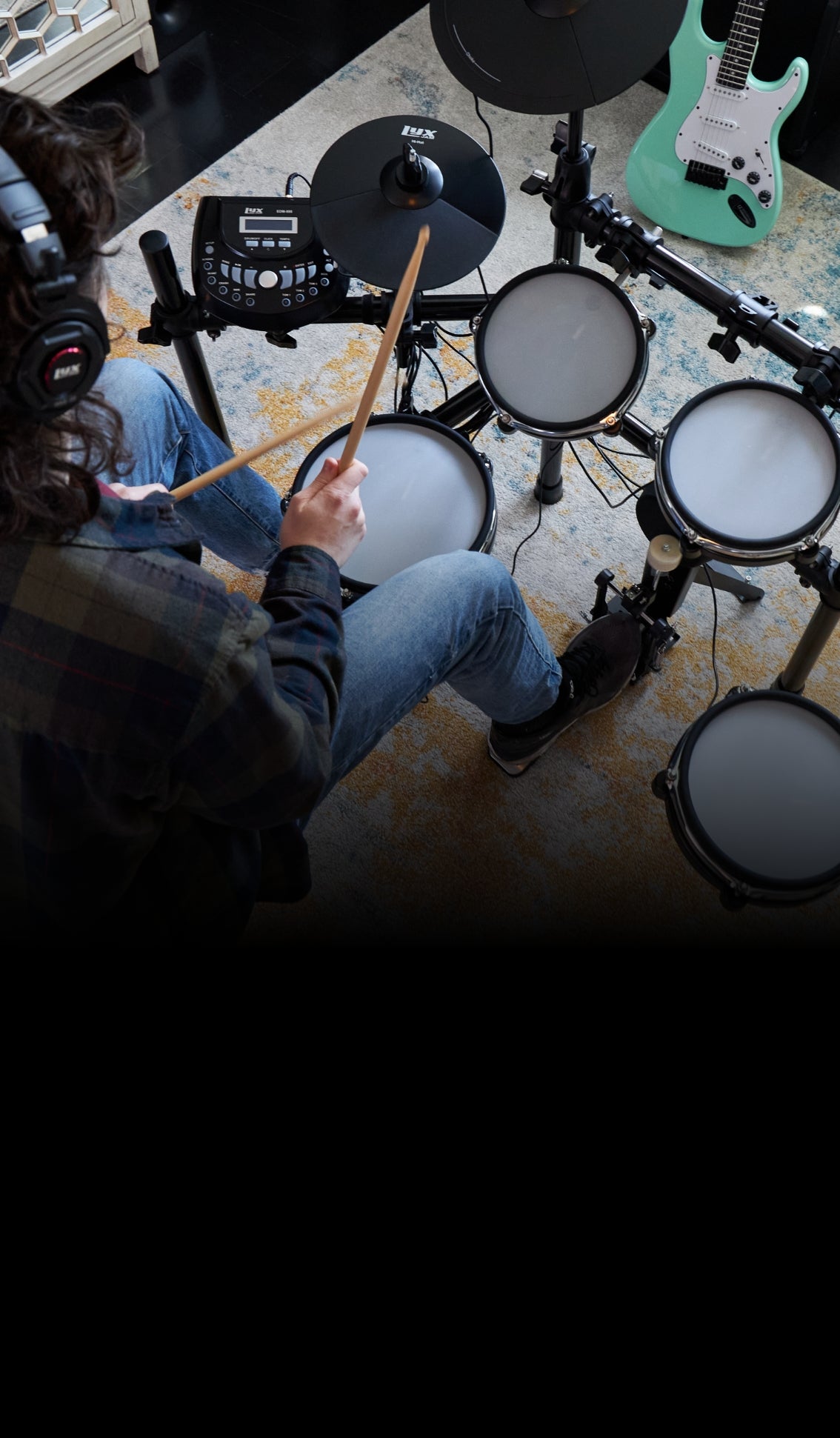 a person playing on the beginner electric drum set 