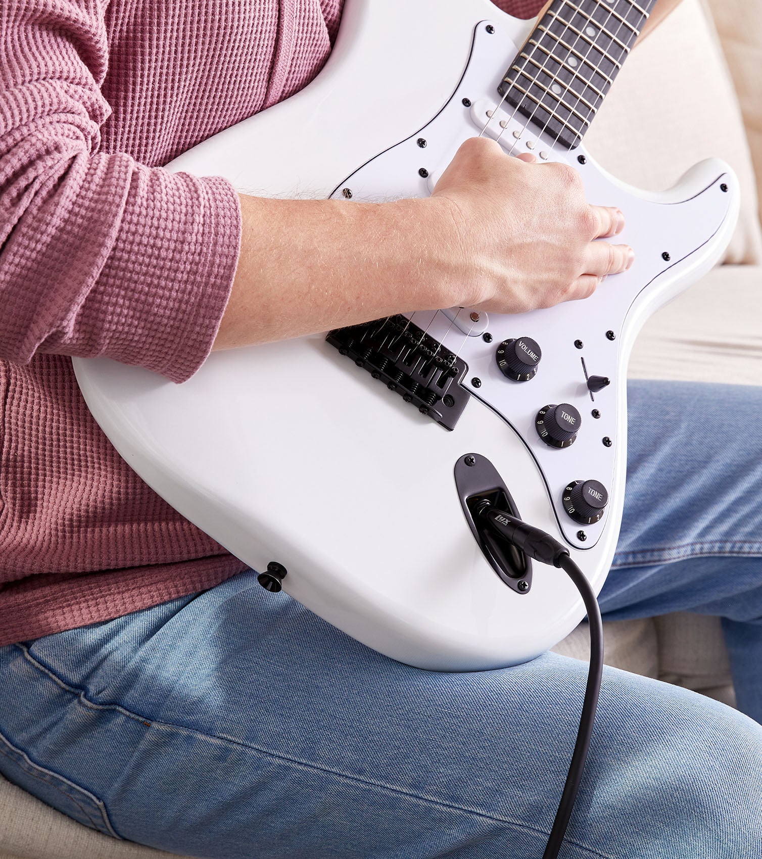 person playing White beginner electric guitar