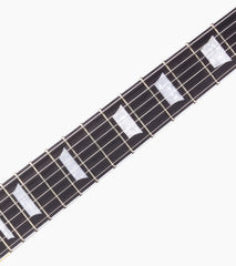 close-up of black les paul inspired electric guitar fretboard