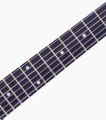 close-up of Green double-cutaway beginner electric guitar fretboard