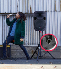 person singing alongside mounted 15” portable battery-powered PA speaker  