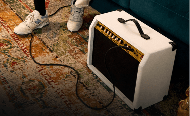 Person playing beginner electric guitar on the portable guitar amp 