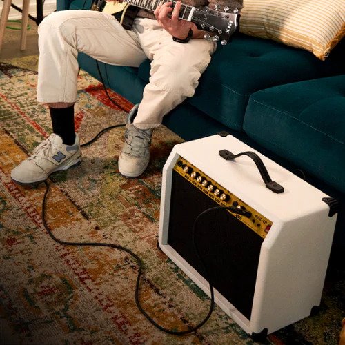 Person playing beginner electric guitar on the portable guitar amp 